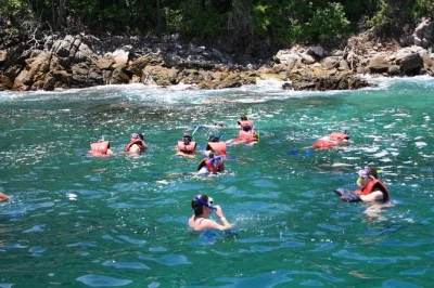 Esplora sentieri nascosti fino a una spiaggia incontaminata nel parco nazionale, fai snorkeling tra le barriere coralline con una guida locale e rilassati con una bevanda. include attrezzatura, traspo