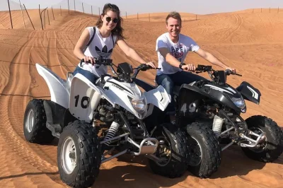 Experience a dubai morning quad bike ride, dune bashing, sand boarding, and camel ride in the red desert. includes hotel pickup, guide, and bottled water.