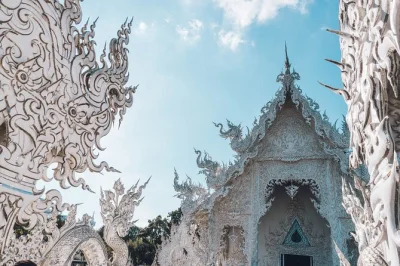 Descubre los templos blanco y azul de chiang rai, visita la aldea karen de cuellos largos y navega por el triángulo dorado, con recogida en hotel y guía local.