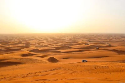 Feel the rush of dune bashing near dubai, share arabic tea at a desert camp, try sandboarding and camel rides, and enjoy a bbq dinner with live shows. includes pickup.