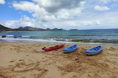 Explore a costa de porto santo de caiaque saindo da praia da calheta, conheça grutas de rochas vulcânicas, ilhotas desertas e praias escondidas com guia local.