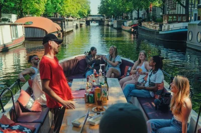 Hear local tales as you cruise amsterdam’s canals in an open electric boat, with drinks, small groups, and a guide sharing real city stories. includes easy boarding.