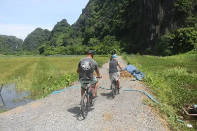 Cycle rural ninh binh, visit local families, hike mua cave, and enjoy a tam coc boat trip. authentic day tour from hanoi with guide and lunch included.