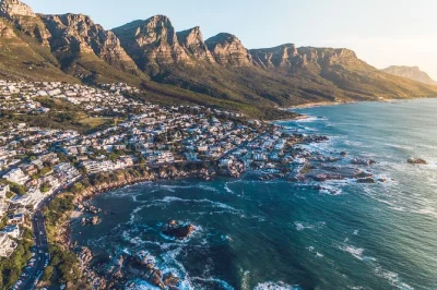 Disfruta un tour en helicóptero por ciudad del cabo sobre table mountain, las playas de clifton y ambos océanos. incluye recogida en v&a waterfront y copa de espumante al aterrizar.