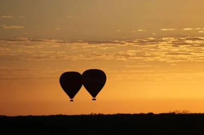 Siente cómo despierta el outback desde el aire en un vuelo en globo al amanecer cerca de alice springs, con vistas a las macdonnell ranges, avistamiento de fauna y brindis con vino espumoso al aterri