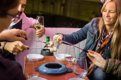 Savor swiss cheese fondue & white wine on a private zurich etuktuk tour through old town, bahnhofstrasse & paradeplatz. includes pickup, guide & lunch.