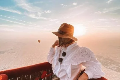 Float above the dubai desert at sunrise, spot wildlife from a hot air balloon, then enjoy breakfast, camel rides & falcon photos. includes transfers from dubai.