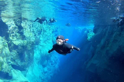 Sinta a água cristalina e gelada da fissura silfra num tour de snorkel com roupa térmica saindo de reykjavik. grupos pequenos, guia especialista, fotos subaquáticas e transporte incluso.