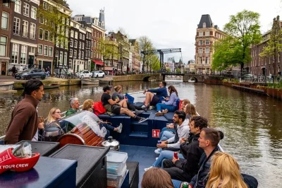 Desfrute de um passeio tranquilo pelos canais de amsterdam em um barco elétrico aberto, com histórias ao vivo do guia e vistas como a magere brug. inclui duas bebidas.