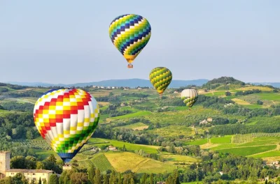 Vola sopra le dolci colline di siena all’alba, ammira castelli e vigneti e festeggia l’atterraggio con una colazione tipica e un calice di prosecco.
