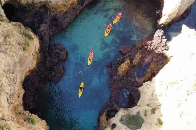 Set out from lagos marina by catamaran, kayak into ponta da piedade’s caves, then swim in clear water. small group, local guide, gear and bottled water included.