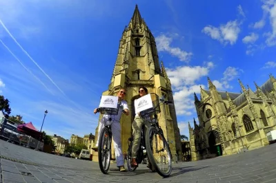 Ride through bordeaux’s unesco streets by bike, see the grosse cloche, bordeaux cathedral, and palais gallien with a local guide—bike and water included.