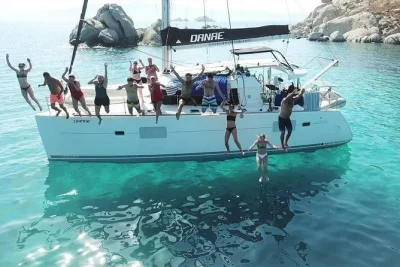 Parti da santorini con una crociera in catamarano, nuota in calette tranquille, gusta un pranzo greco a bordo e assapora vino e birra. include attrezzatura per snorkeling e pick-up di gruppo.