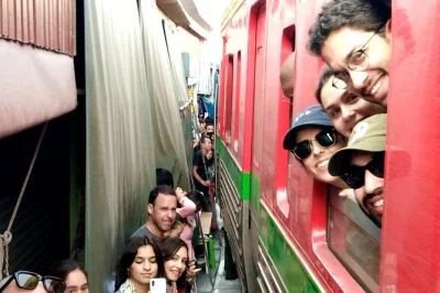 Feel the rush at maeklong railway market, float through damnoen saduak’s canals, and taste coconut treats on a bangkok day trip—includes hotel pickup and local guide.