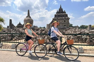 Pedal through rice fields near prambanan, visit a hidden temple, try emping chip making, and taste fresh tofu with a local guide. includes water and pickup.
