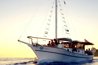 Partez d’oia pour une croisière au coucher du soleil dans la caldeira de santorin, nagez à thirassia, savourez un dîner grec à bord et admirez le ciel changer depuis le pont. transfert hôtel in