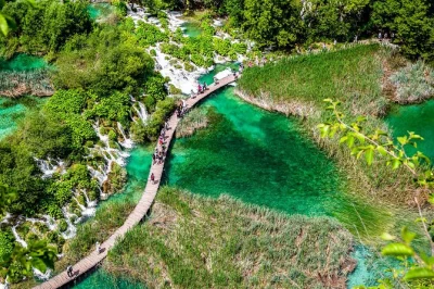 Découvrez les lacs turquoise, sentiers forestiers et cascades des lacs de plitvice lors d’une excursion d’une journée depuis zagreb. entrée coupe-file, balade en bateau et train inclus.