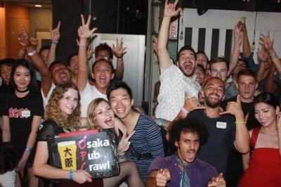 Vivi la vita notturna di osaka con un pub crawl guidato a shinsaibashi, sconti sui drink, ingresso in club e un gruppo che diventa subito amico. include shot e giochi di gruppo.