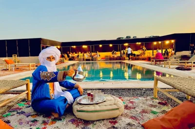 Découvrez le désert d’agafay au coucher du soleil près de marrakech avec une balade à dos de chameau, un dîner marocain sous les étoiles et de la musique berbère en live. transfert hôtel inc