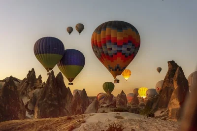 Vive la emoción tranquila de un paseo en globo al amanecer sobre los valles de cappadocia, con recogida en hotel, piloto local y celebración tras el vuelo.