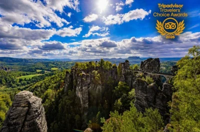 Scopri la storia di terezin, esplora i labirinti di arenaria della svizzera boema, gusta il pranzo a tisá e attraversa il ponte bastei—con trasferimento incluso.