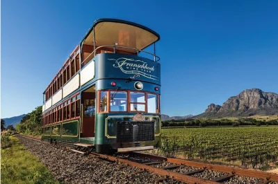 Erlebe die weinwelt von franschhoek bei einer entspannten tages-tour ab kapstadt mit wine tram, flexiblem ein- und aussteigen und rückfahrt im komfortablen bus.