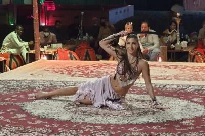 Feel the rush of dune bashing in dubai’s red sands, try sandboarding, watch sunset, and share a bbq dinner under the stars with live shows. includes hotel pickup.