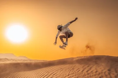 Vivi l’emozione delle dune rosse di dubai con un safari al tramonto privato: 4x4, sandboarding, giro in cammello e cena bbq deluxe nel campo sotto il cielo stellato.