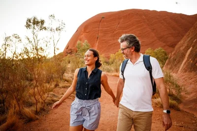 Feel the desert wake up on a guided uluru base walk. see ancient rock art, sacred sites, and kantju gorge waterfall. includes breakfast & hotel pickup.