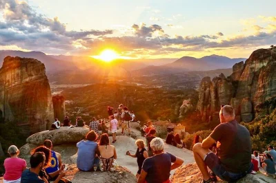 Scopri la magia di meteora al tramonto, visita 6 monasteri, esplora antiche grotte e la chiesa bizantina con guida locale e trasferimento dall’hotel incluso.