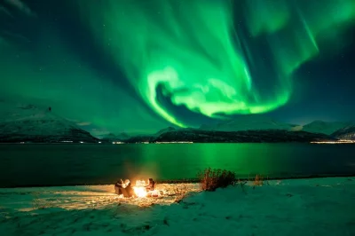Chase the northern lights from tromsø in a small group, with a local guide, bonfire dinner, pro photos, heated restroom and real-time sky tracking. includes pickup.