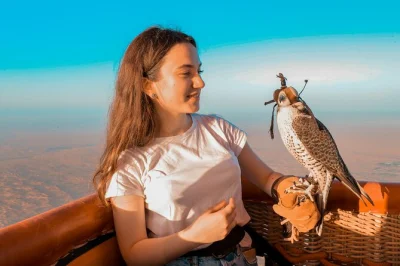 Vive el amanecer en el desierto de dubái desde un globo aerostático, observa un halcón volar a tu lado y disfruta de un café en el aire fresco. incluye traslados y guía.