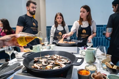 Descubre madrid desde su cocina, aprende los secretos de la paella con chefs locales, disfruta vino español sin límite y comparte un festín de cinco platos en mesa común.
