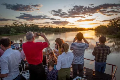 Erlebe den sonnenuntergang am thomson river bei longreach, genieße ein herzhaftes camp oven dinner bei smithy’s und live-musik unter dem sternenhimmel. inklusive flussfahrt & dinner-show.