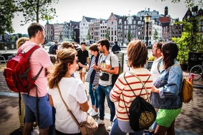 Scopri il cuore di amsterdam con un tour a piedi in piccolo gruppo, da piazza dam al quartiere a luci rosse. guida locale, opzione giro in battello e storie autentiche incluse.