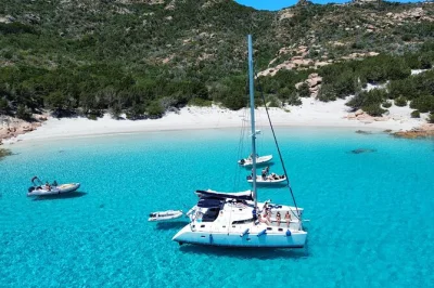 Desde cannigione navega en catamarán por las islas maddalena, nada en calas turquesas, disfruta la playa rosa y un almuerzo típico sardo con bebidas incluidas.