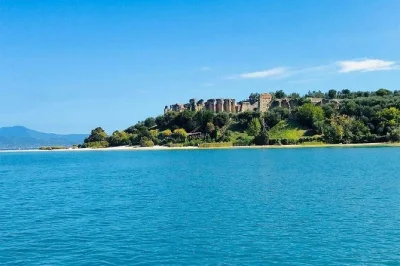 Sinta a brisa do lago de garda com um mini cruzeiro em sirmione, conheça o castelo scaligero, a villa da maria callas e as grutas de catullo. tour em grupo pequeno com capitão local.