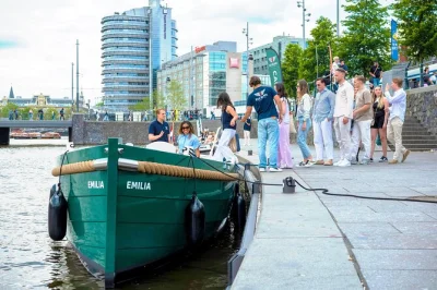 Scivola silenzioso tra le case dei canali di amsterdam, il skinny bridge e i quartieri vivaci su una barca elettrica con skipper locale e piccolo gruppo. opzione bevande inclusa.