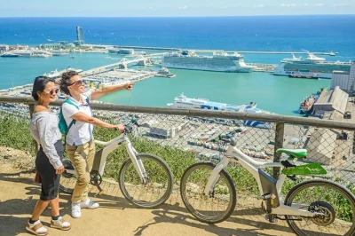 Siente barcelona en e-bike, sube en teleférico a montjuïc y navega la costa en grupo reducido. guía, entradas y equipo incluidos.