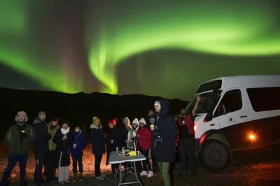 Explore a noite islandesa com um tour de 4x4 para ver a aurora boreal saindo de reykjavik, com transporte, fotos, chocolate quente, doces típicos e guia local em inglês ou espanhol.