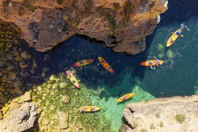 Feel the algarve coast up close on a kayak tour from lagos to ponta da piedade caves, with catamaran support, time to swim, and a friendly local guide included.