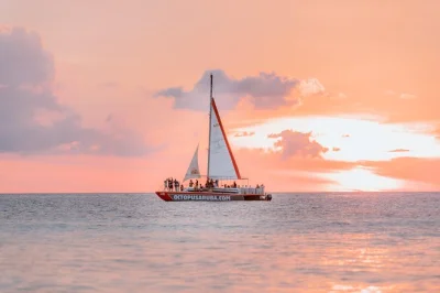 Sail aruba’s coast at sunset on a lounge catamaran with cocktails, savory bites, and personal crew service. includes shuttle boat transfer and local souvenirs.