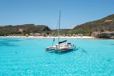 Sail curacao’s west coast by catamaran, snorkel kokomo beach, swim at cas abao, explore the blue room cave, and enjoy a bbq lunch—includes drinks & return bus.