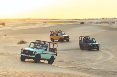 Feel the dubai desert in a vintage g-class, ride camels, share emirati coffee at al marmoom oasis, and stargaze after a 5-course dinner. includes pickup.