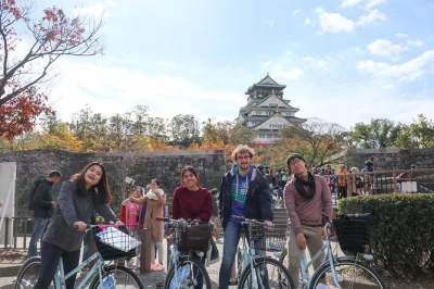 Scopri osaka in bici, visita il castello di osaka, assaggia l'okonomiyaki e gusta tè verde con snack. tour in piccolo gruppo con bici a noleggio e guida locale inclusi.