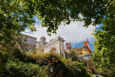 Descubra os palácios encantados e jardins secretos de sintra, com entrada guiada no palácio da pena e quinta da regaleira, tempo livre no centro histórico e traslado saindo de lisboa.