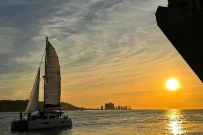 Descubra lisboa do tejo ao entardecer, com vinho português, luzes da cidade e histórias locais. inclui skipper e todas as taxas.