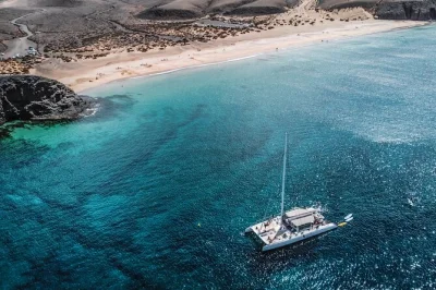 Feel the atlantic breeze on a lanzarote catamaran tour to papagayo beaches, with swimming, snorkeling, and a fresh lunch. includes drinks, gear, and pickup.