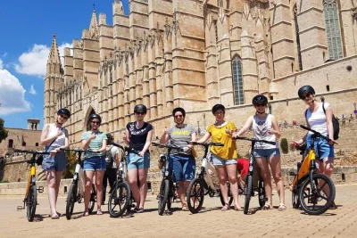 Sinta a brisa do mar em um tour de e-bike por palma em grupo pequeno. explore a plaza mayor, a catedral de palma e os banhos Árabes com um guia local. capacete e bicicleta inclusos.