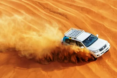 Experience an abu dhabi desert safari: 4x4 dune bashing, camel ride, sandboarding, bbq dinner, and belly dancing. book your evening adventure now.